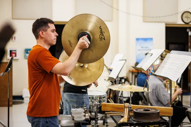 Percussionist performing a cymbal crash